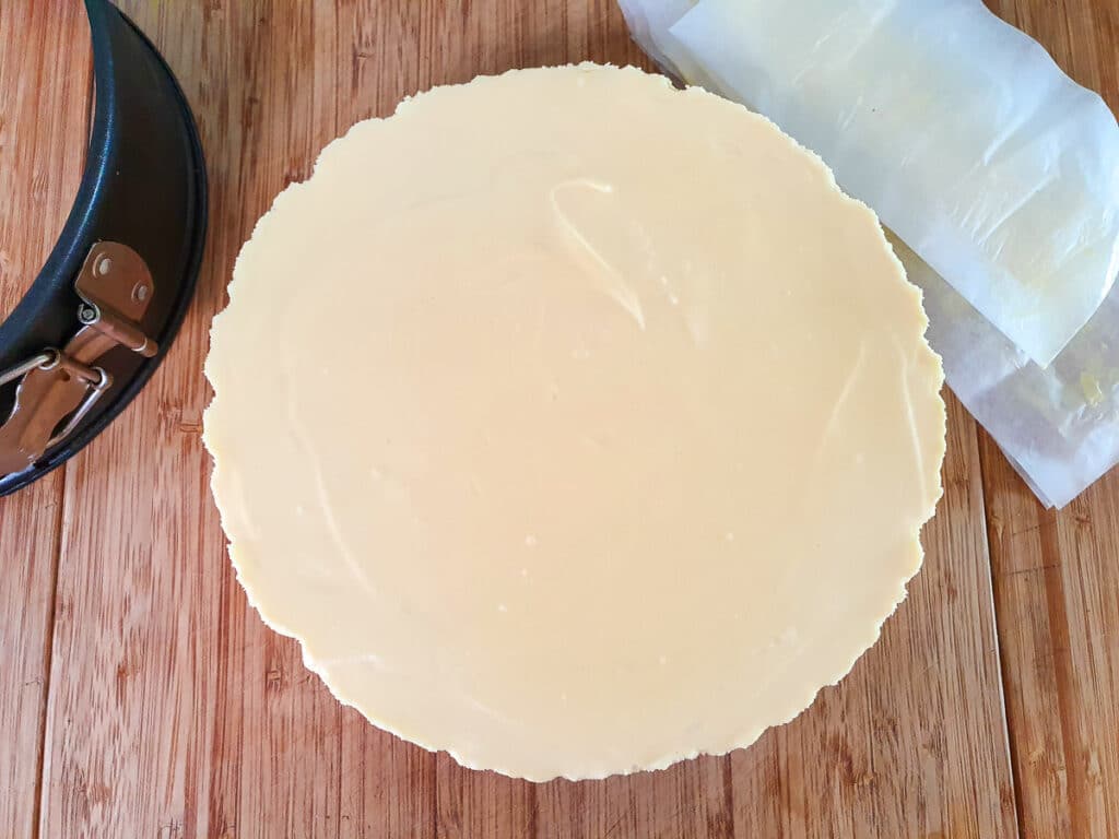 Removing baking paper from around cheesecake.