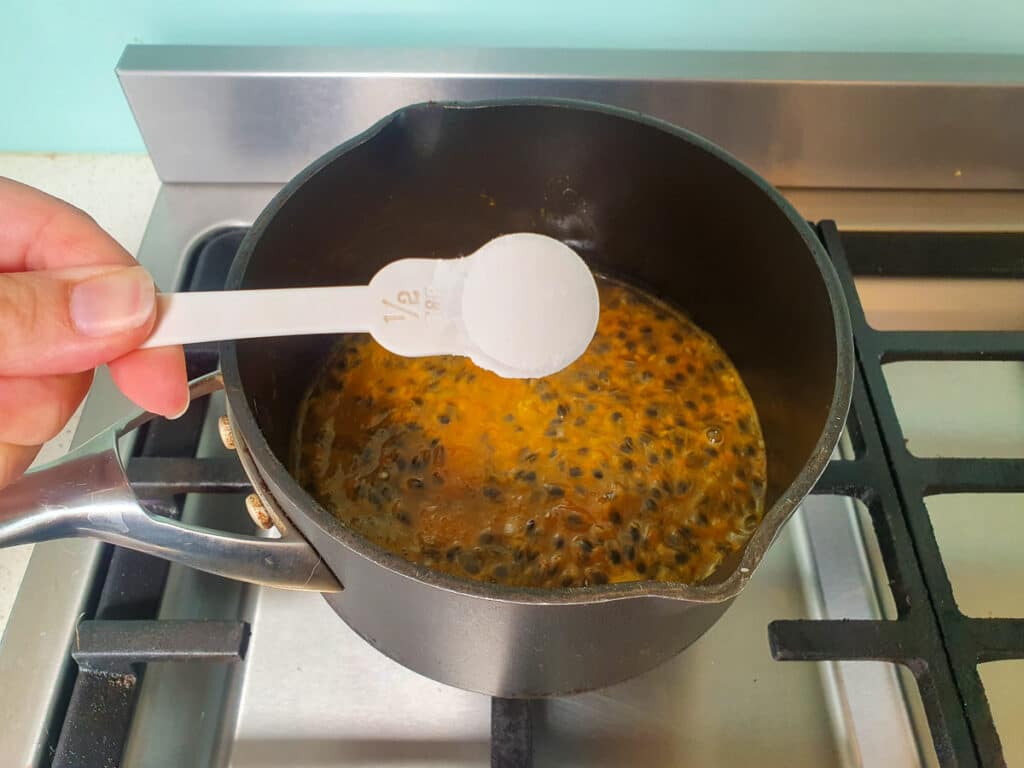 Adding tapioca starch to pot on stove.