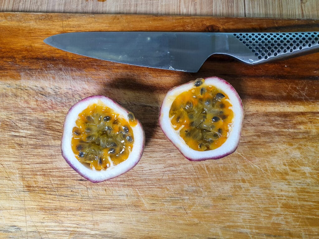 Cutting open passion fruit to scoop out pulp.