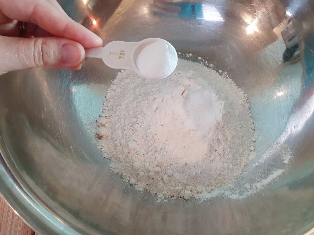 Adding baking powder to flour.