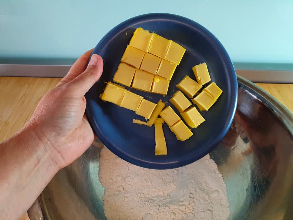 Adding butter to flour.