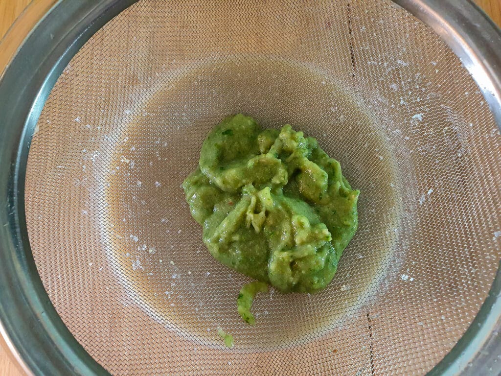 Straining whole blitzed feijoa.