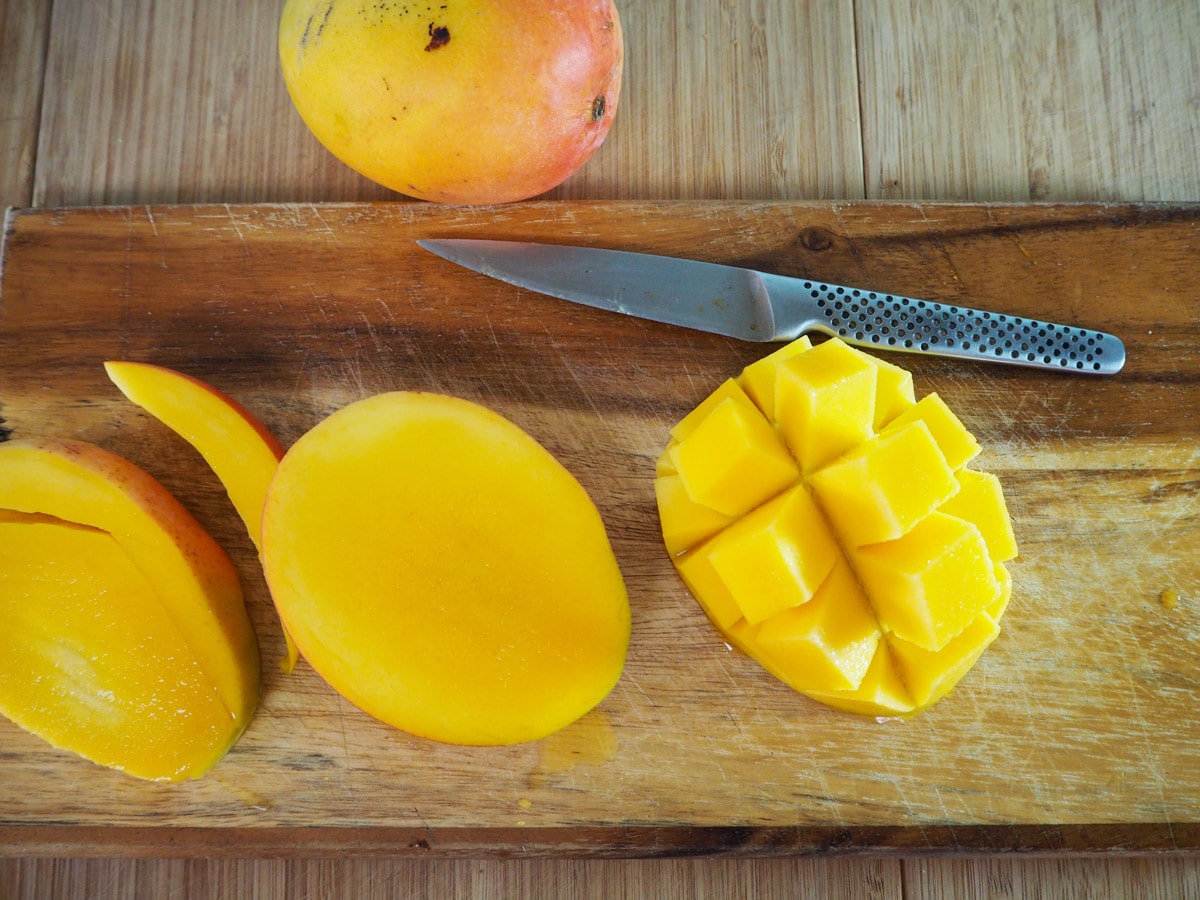 Slicing mangoes to remove flesh.