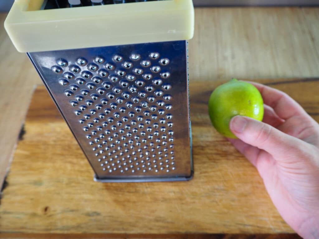 Zesting the lime with a box grater.