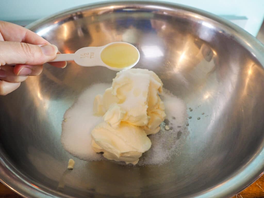 Adding lime juice to sugar and cream cheese.