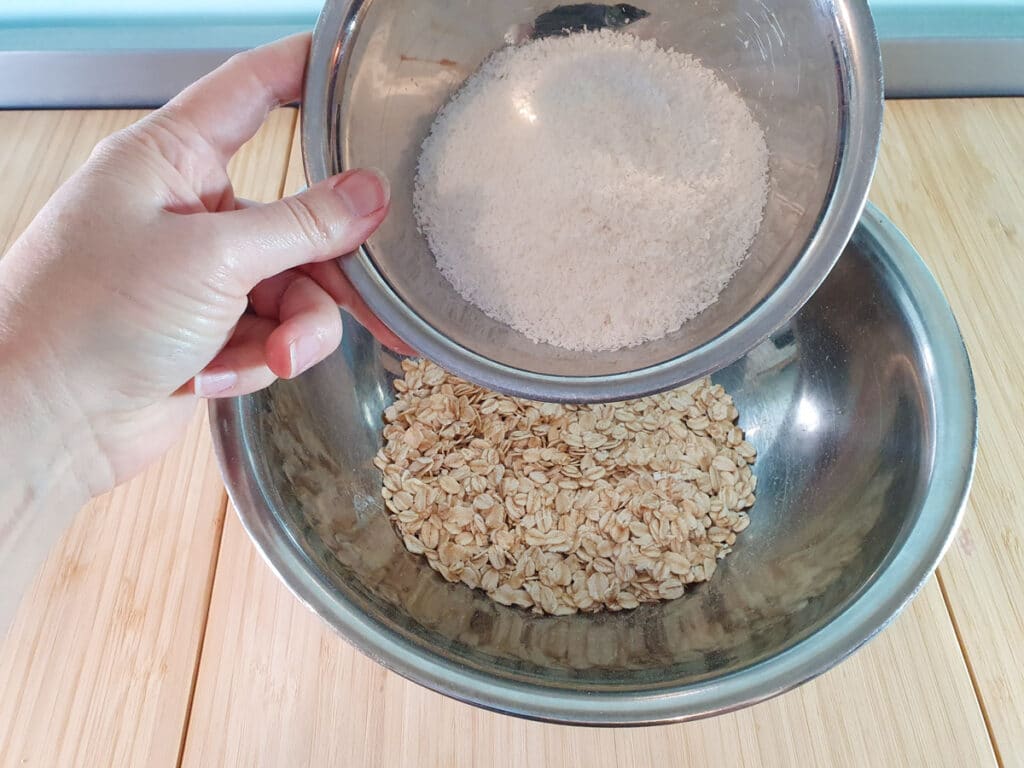 Adding desiccated coconut to oats.