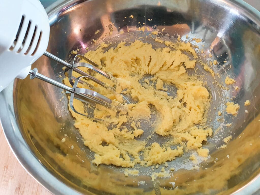 Feijoa cake 7 Beating sugar and butter together with hand held electric beaters.
