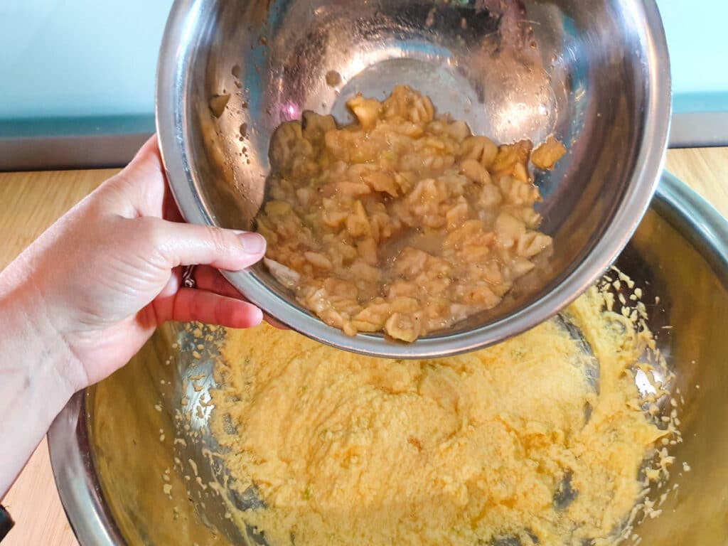 Adding mashed feijoas to wet cake mix.