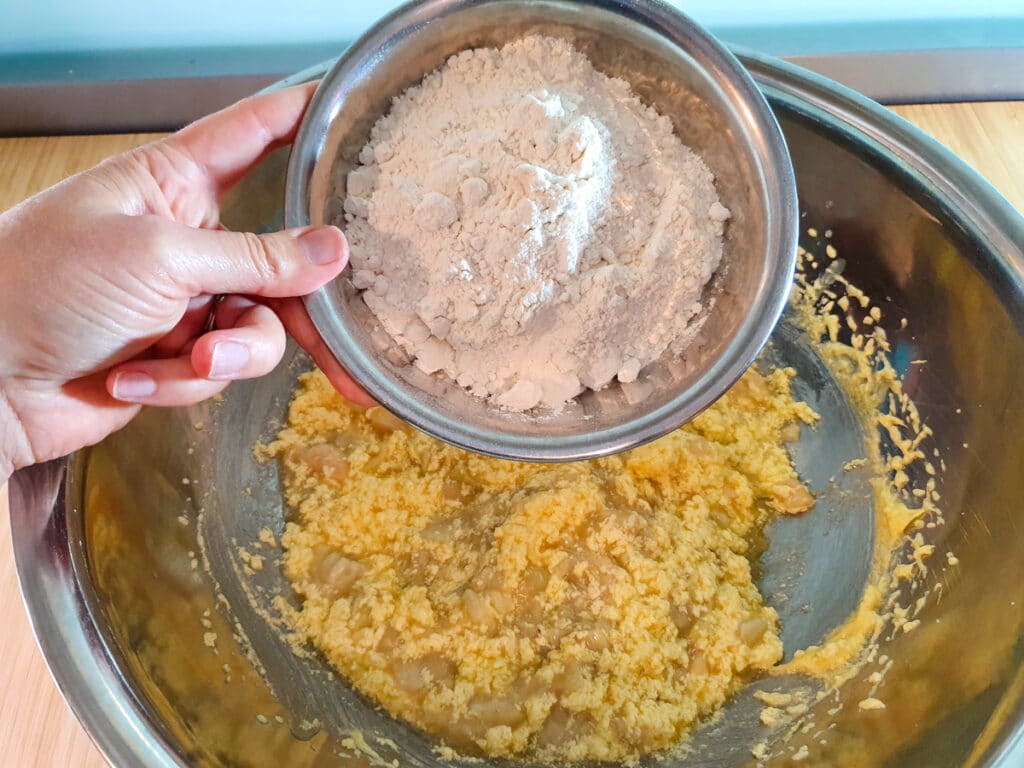 Adding flour to wet cake mix.