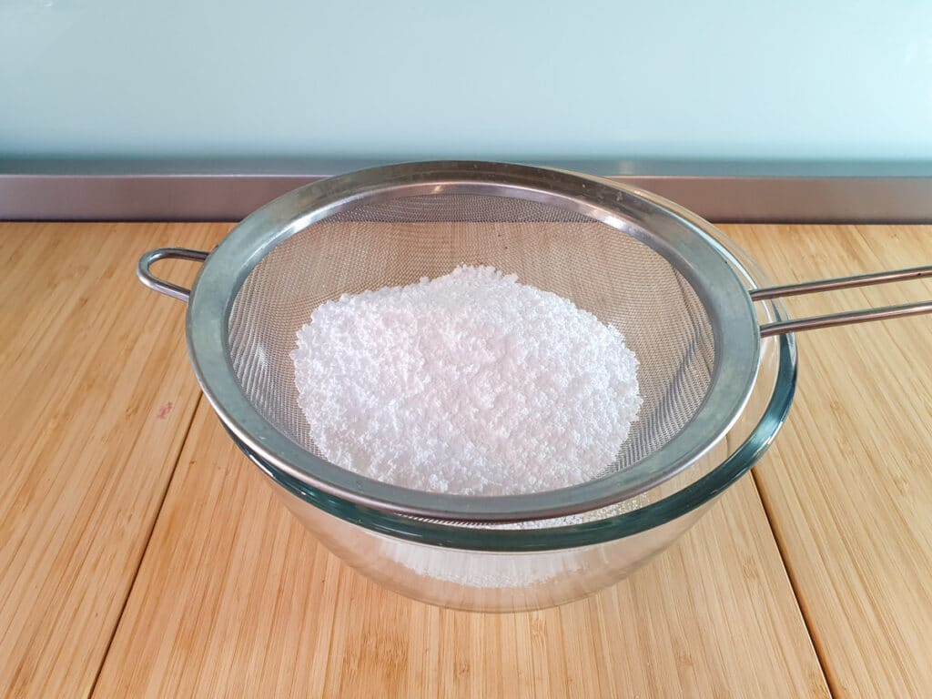 Sifting icing sugar.