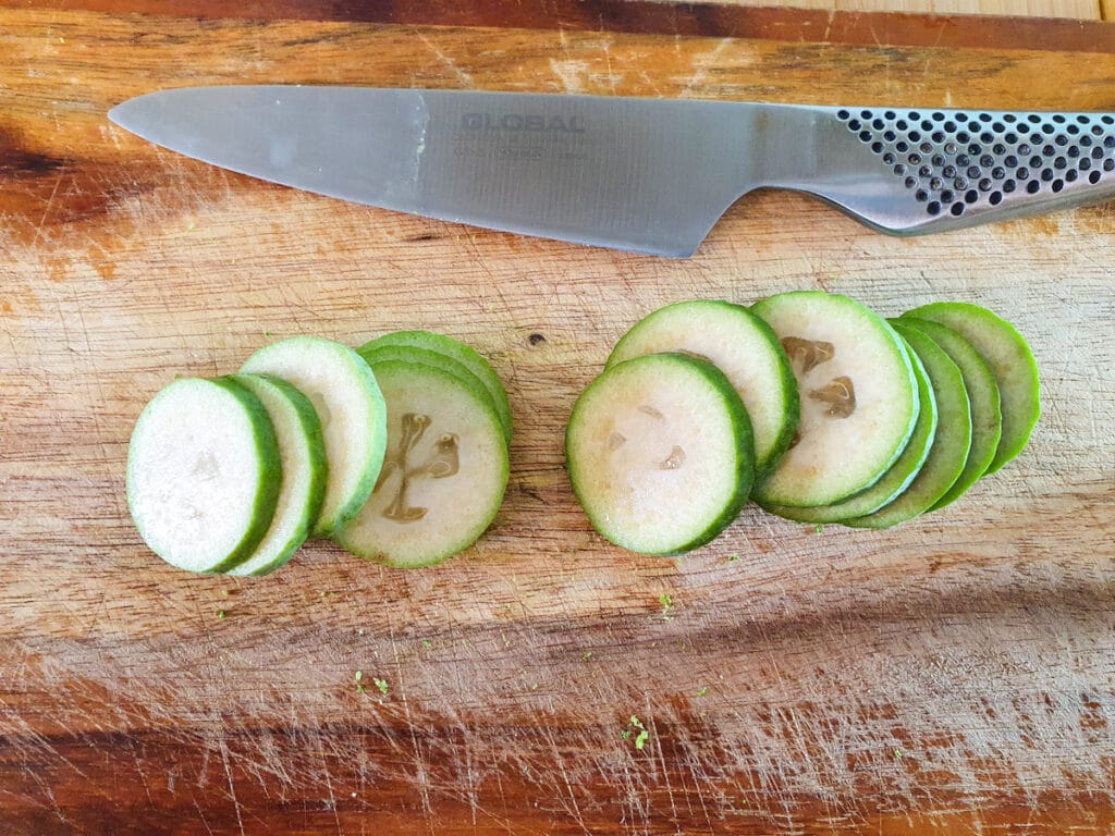 Feijoa cake 19 Slicing fresh feijoas into thick coins to decorate cake.