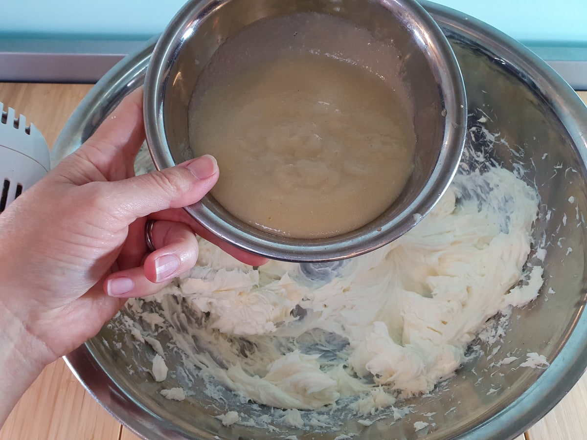 Adding strained feijoa pulp to cream cheese mix.