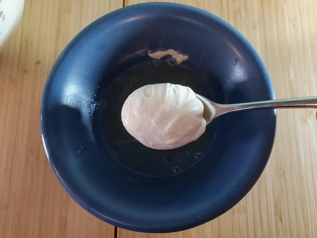 Adding cream to melted gelatin to temper it.