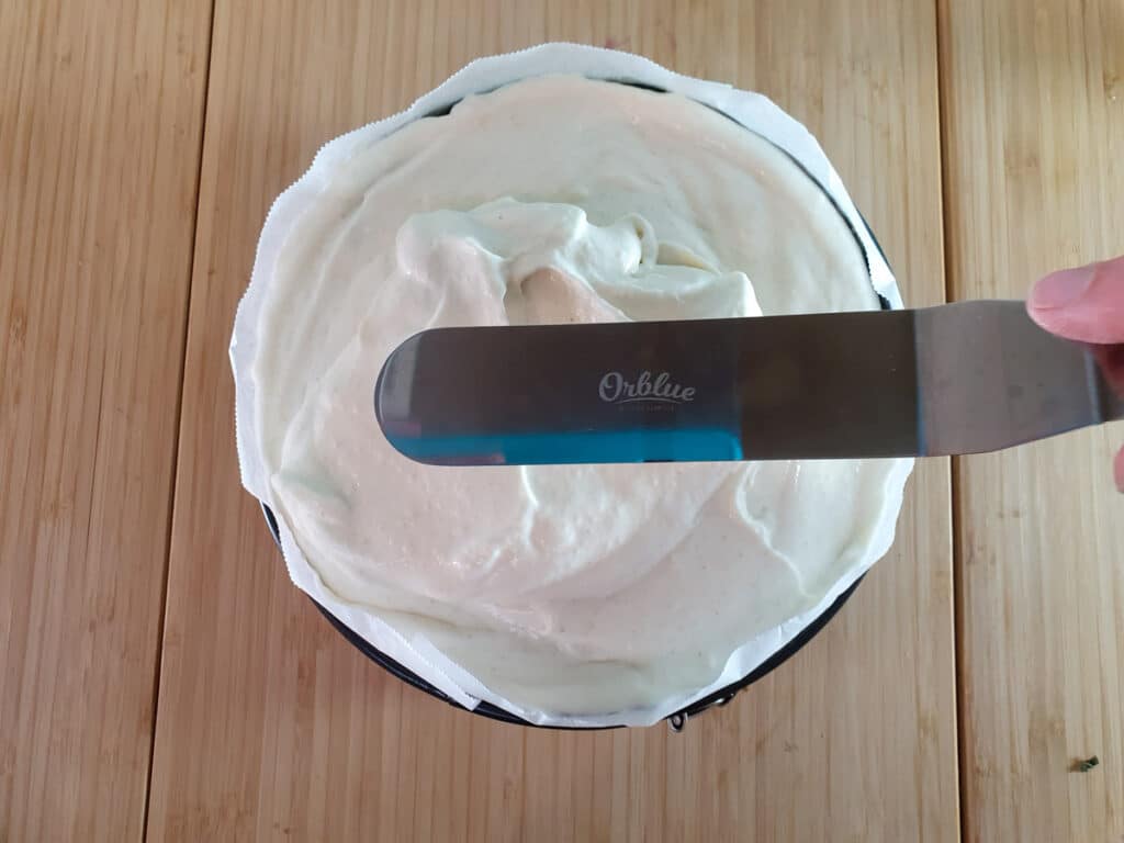 Smoothing down cheesecake filling with an offset spatula.