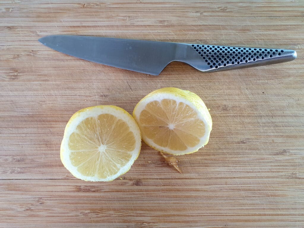 Slicing open lemons to juice after zesting the outside.