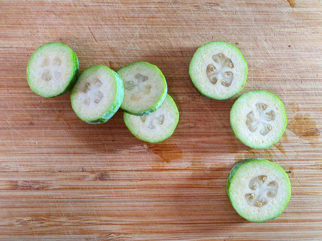 Slicing feijoa disks to decorate cheesecake with.