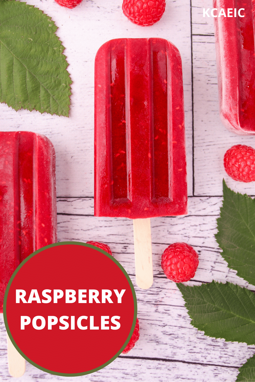 Raspberry popsicles 13 Raspberry popsicles with fresh raspberries and leaves, with text overlay, raspberry popsicles and KCAEIC.