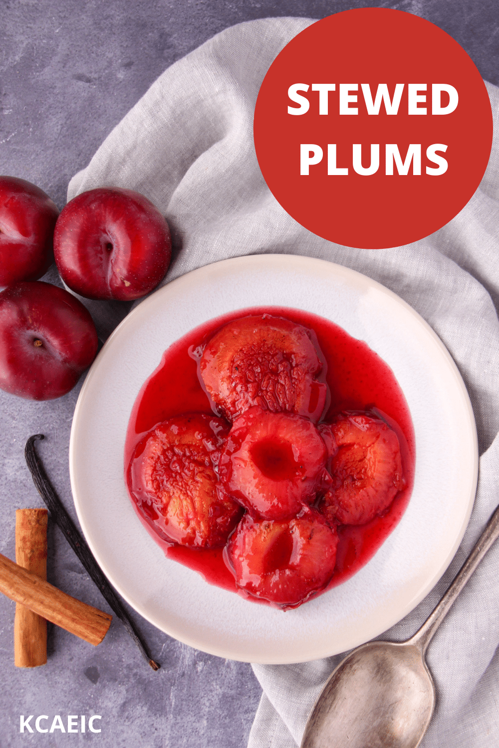 Stewed plums with a vintage serving spoon, fresh plums, cinnamon stick and vanilla pod on the side, with text overlay, Stewed plums, KCAEIC.