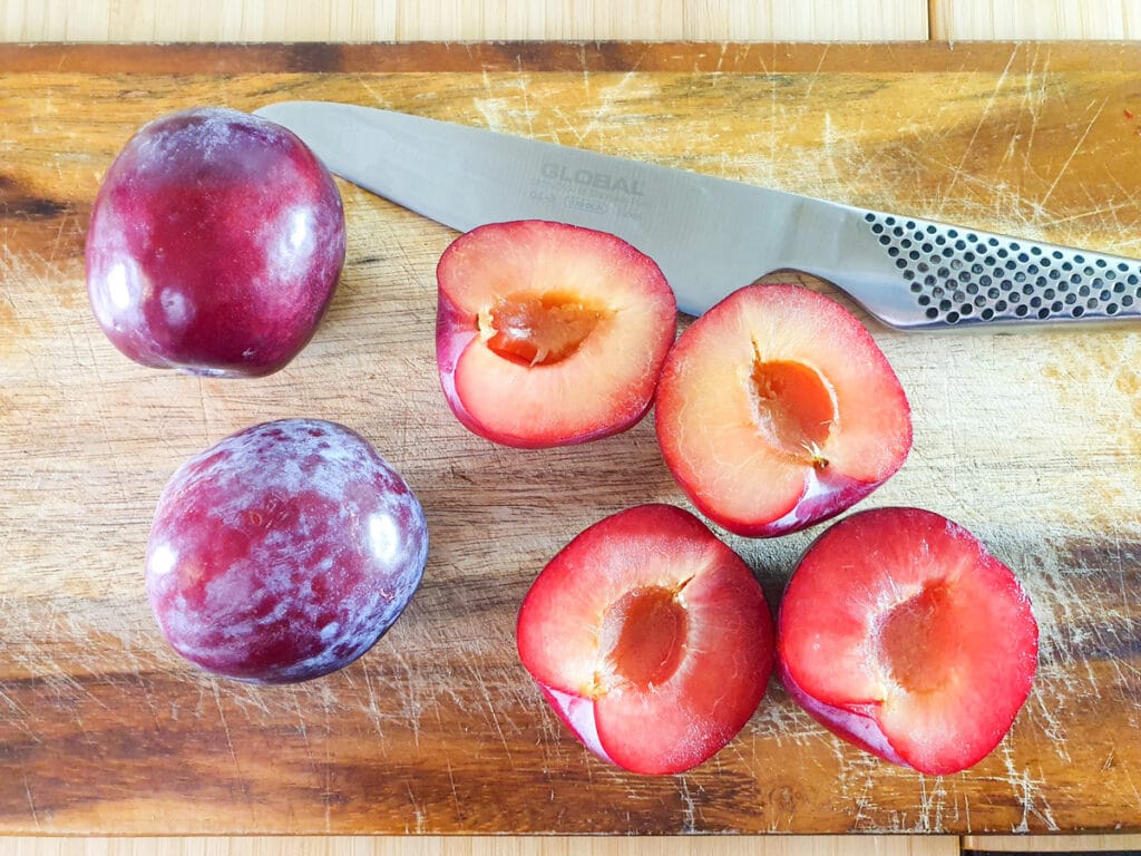 Stewed plums 4 Slicing plums in half and removing stones.