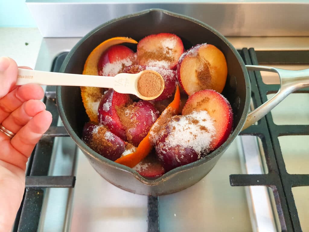 Stewed plums 11 Adding cinnamon to plumbs.