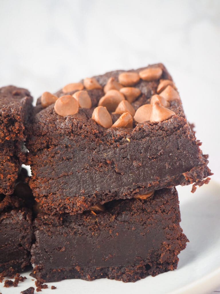 Close up side view of short stack of eggless brownies.