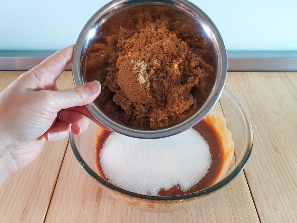 Adding brown sugar to brownie mix.