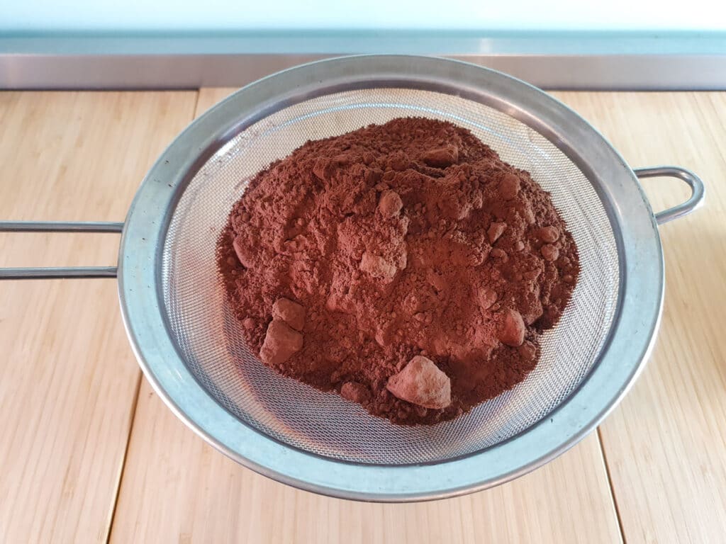Sifting flour, cocoa powder, salt and baking powder into brownie mix.