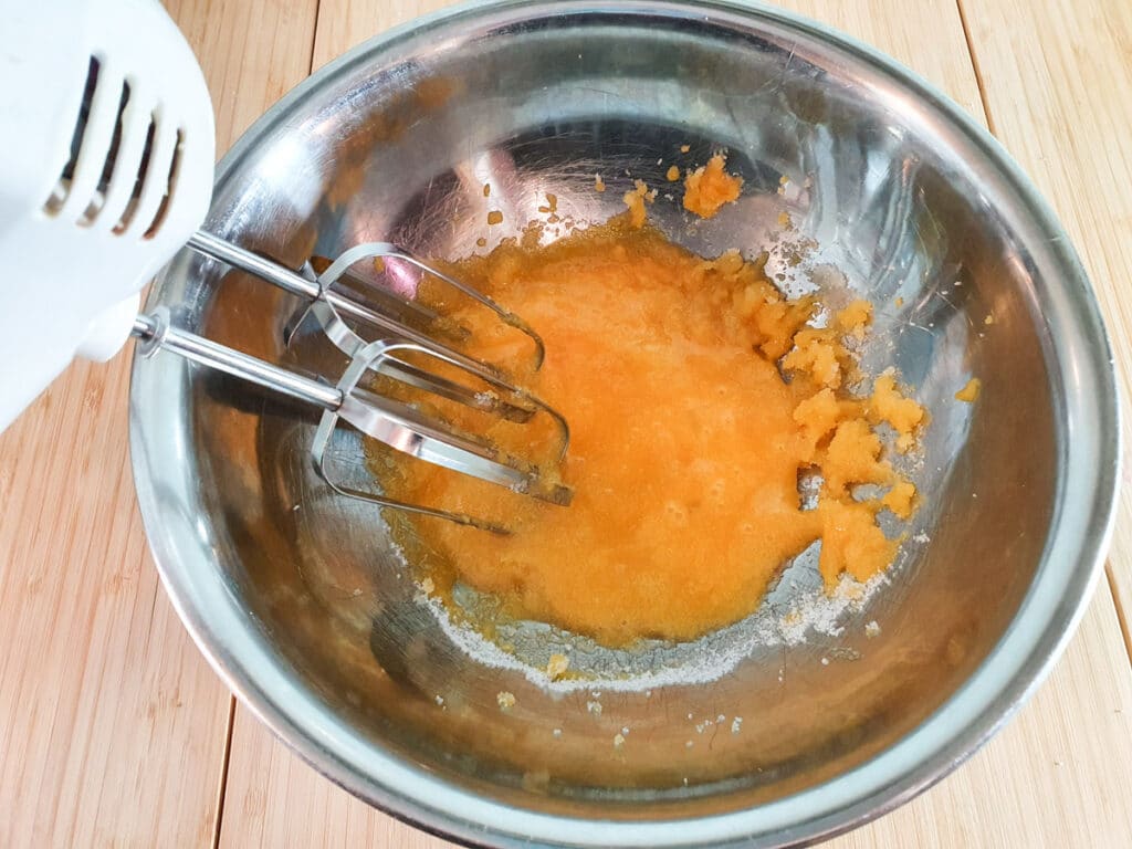 Starting to blend egg yolks and sugar, showing bright yellow color.