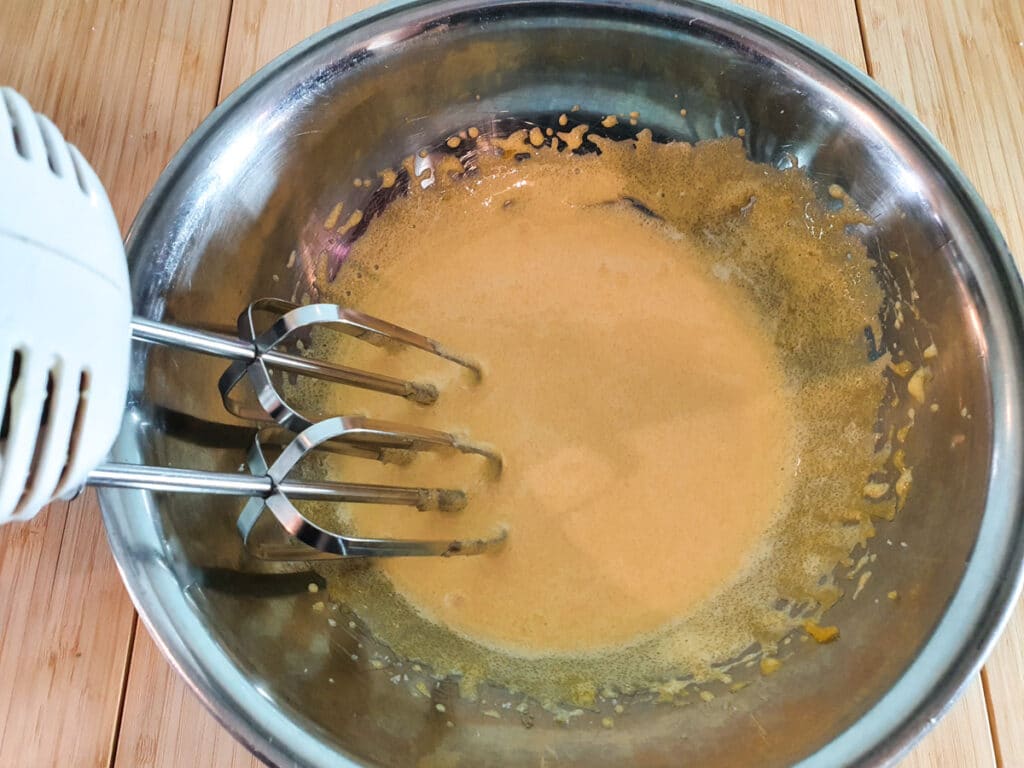 Blended egg yolks and sugar, showing pale foamy color.