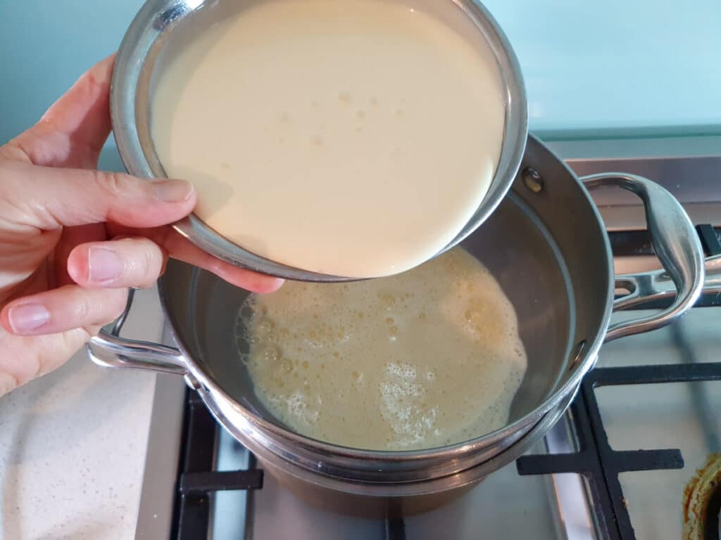 Adding cream to ice cream mix.