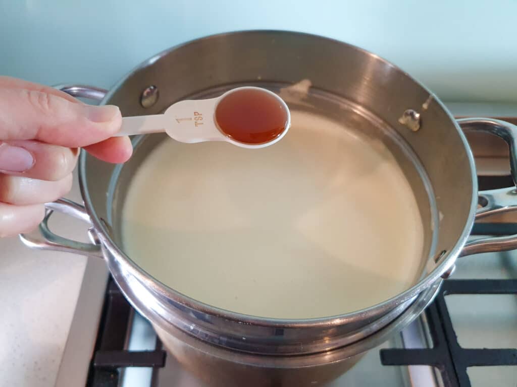 Adding vanilla essence to ice cream base.