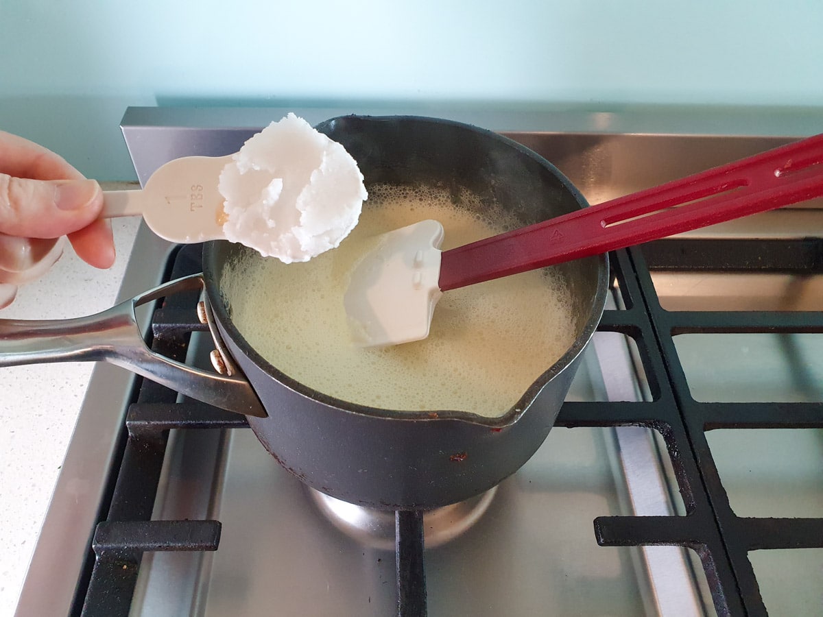 Adding refined coconut oil to pot.