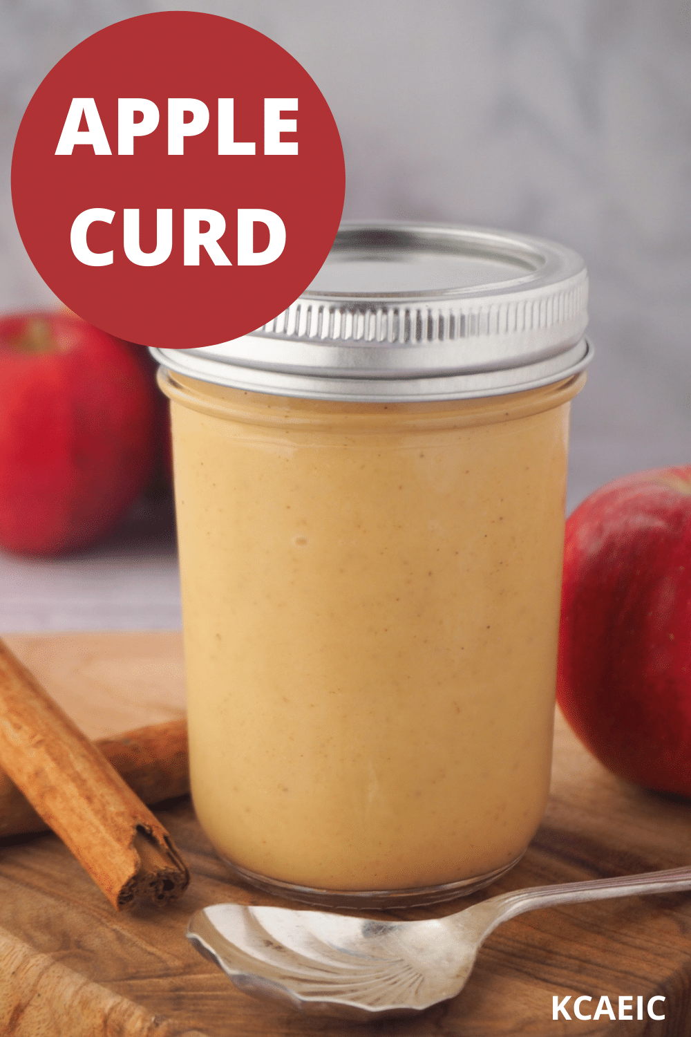 Jar of apple curd to spoon, fresh apples, cinnamon sticks and text overlay, apple curd and KCAEIC.
