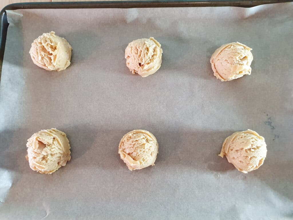 Cookies on lined baking tray ready to bake.