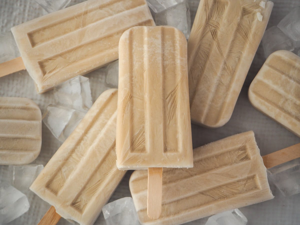 Coconut popsicles 8 Pile of scattered coconut popsicles with ice.