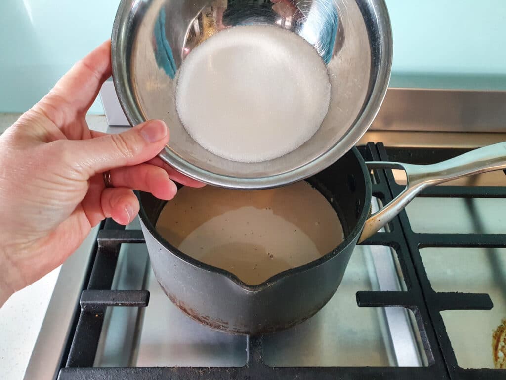 Adding sugar to pot.