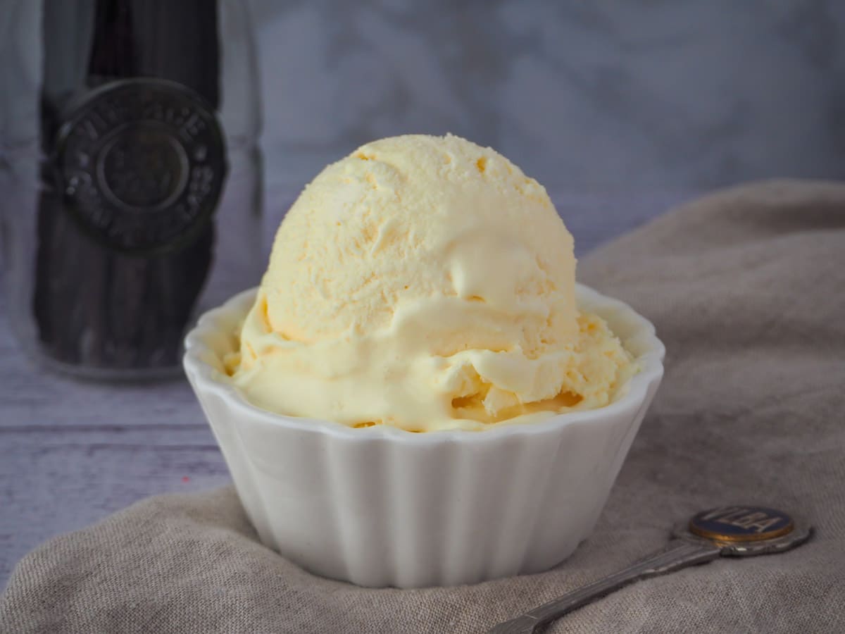 Three ingredient ice cream with spoon and jar of vanilla beans.