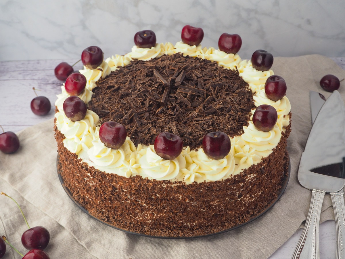 Traditional Black Forest Cake 37 Cake with silver serving ware.