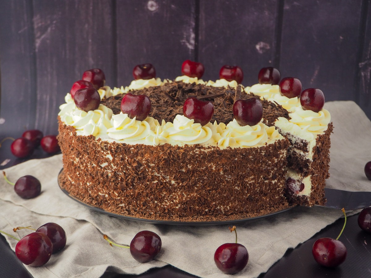 Traditional Black Forest Cake 3 Taking out of slice of cake, with fresh cherries.