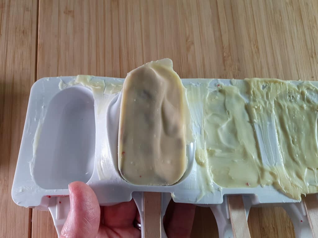 Carefully popping popsicle cakes out of molds.