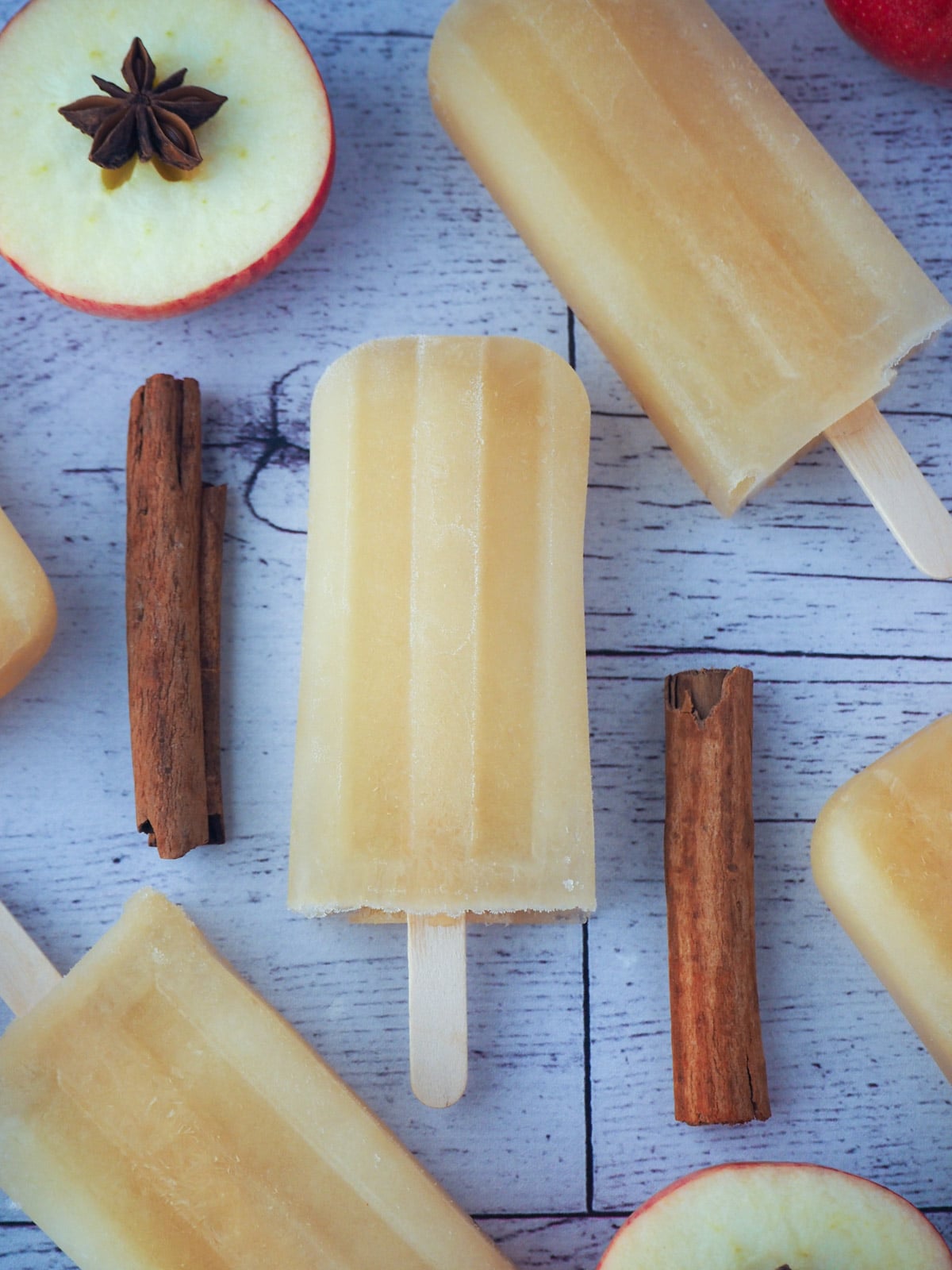 Apple cider popsicles with spices and fresh apples.