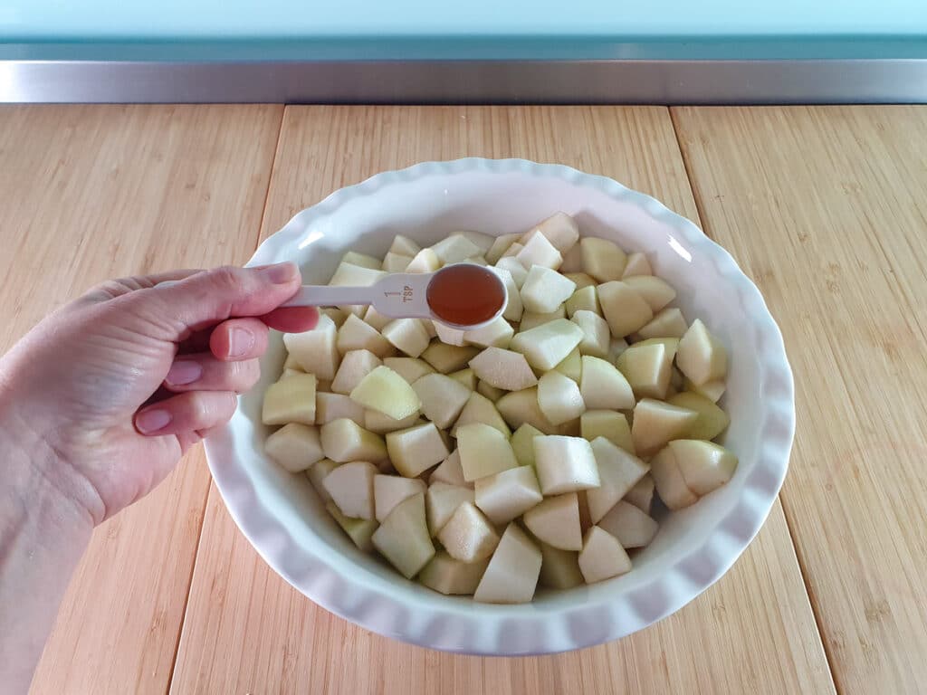 Pear crumble 5 Adding vanilla extract to pears.