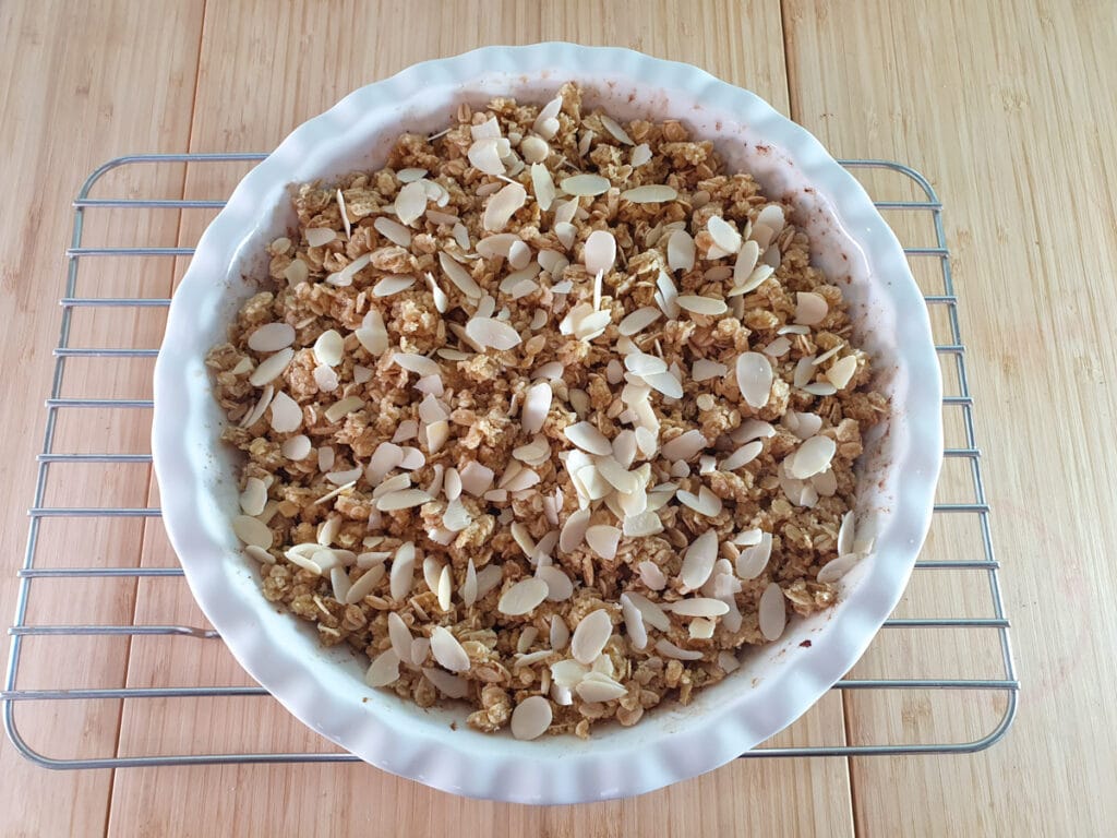 Crumble ready to bake with crumble topping and flaked almonds sprinkled on top.