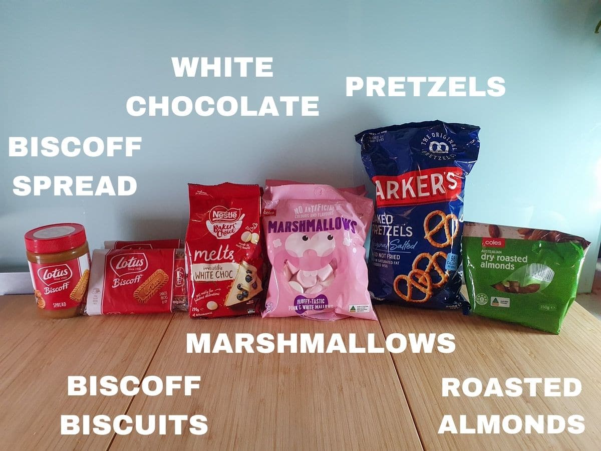 ingredients, smooth biscoff spread, biscoff biscuits, white chocolate, marshmallows, pretzels, roasted almonds.