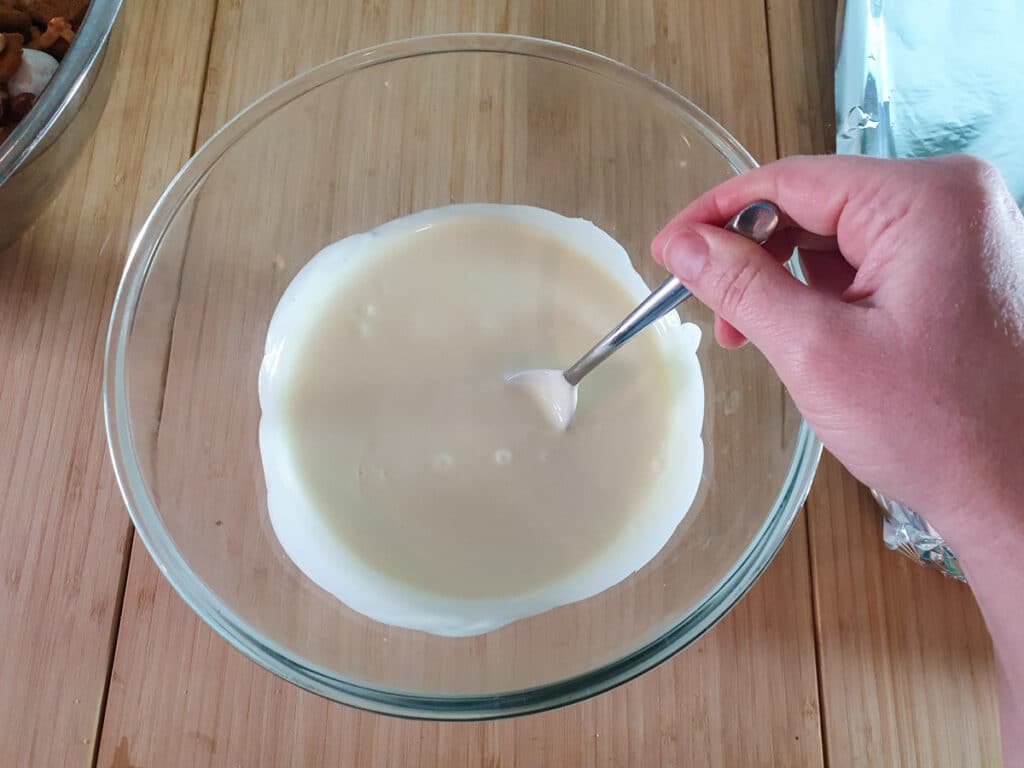 Stirring white chocolate to ensure its smooth and melted.