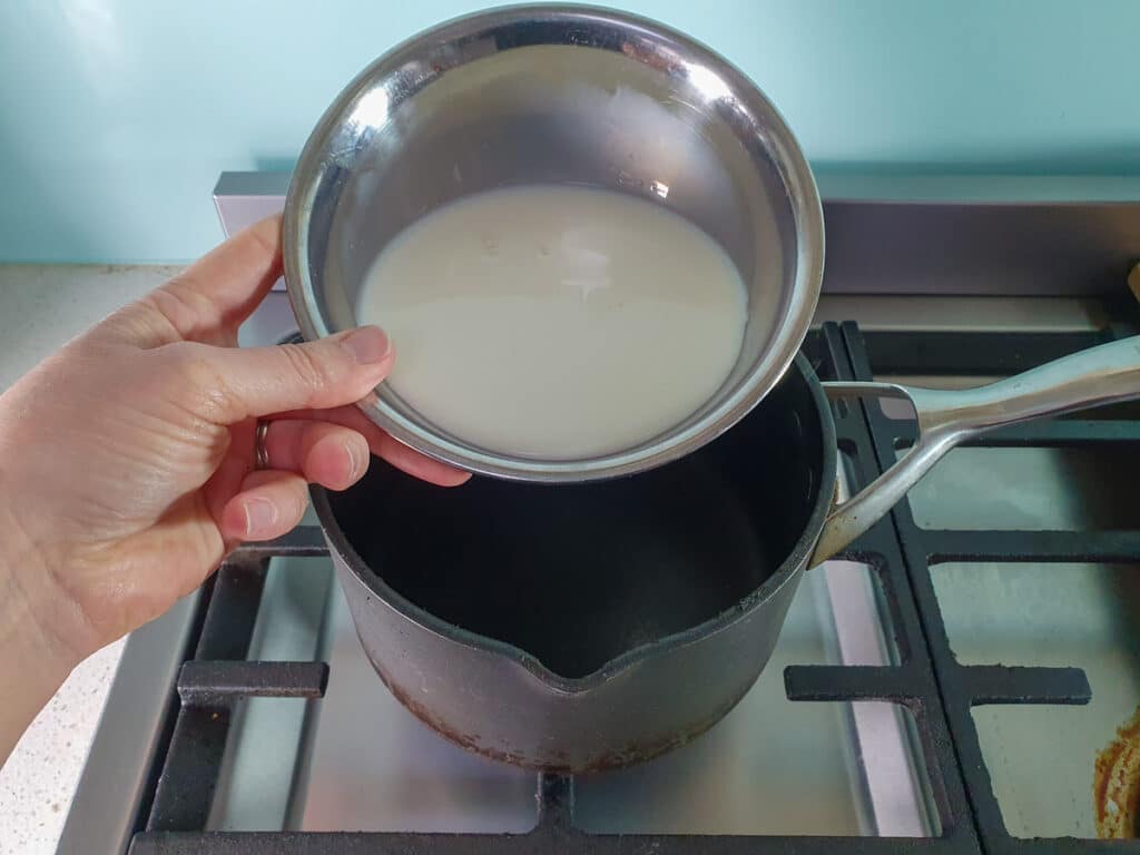 Black Forest Ice Cream 5 adding milk to pot on stove.