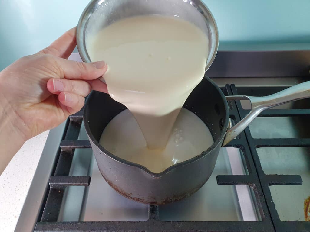 Black Forest Ice Cream 6 adding cream to pot on stove top.