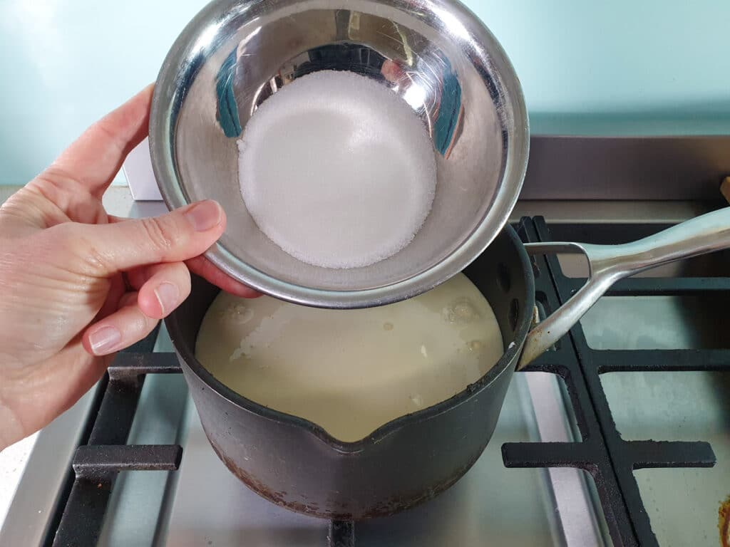 Black Forest Ice Cream 7 adding sugar to pot on stove.