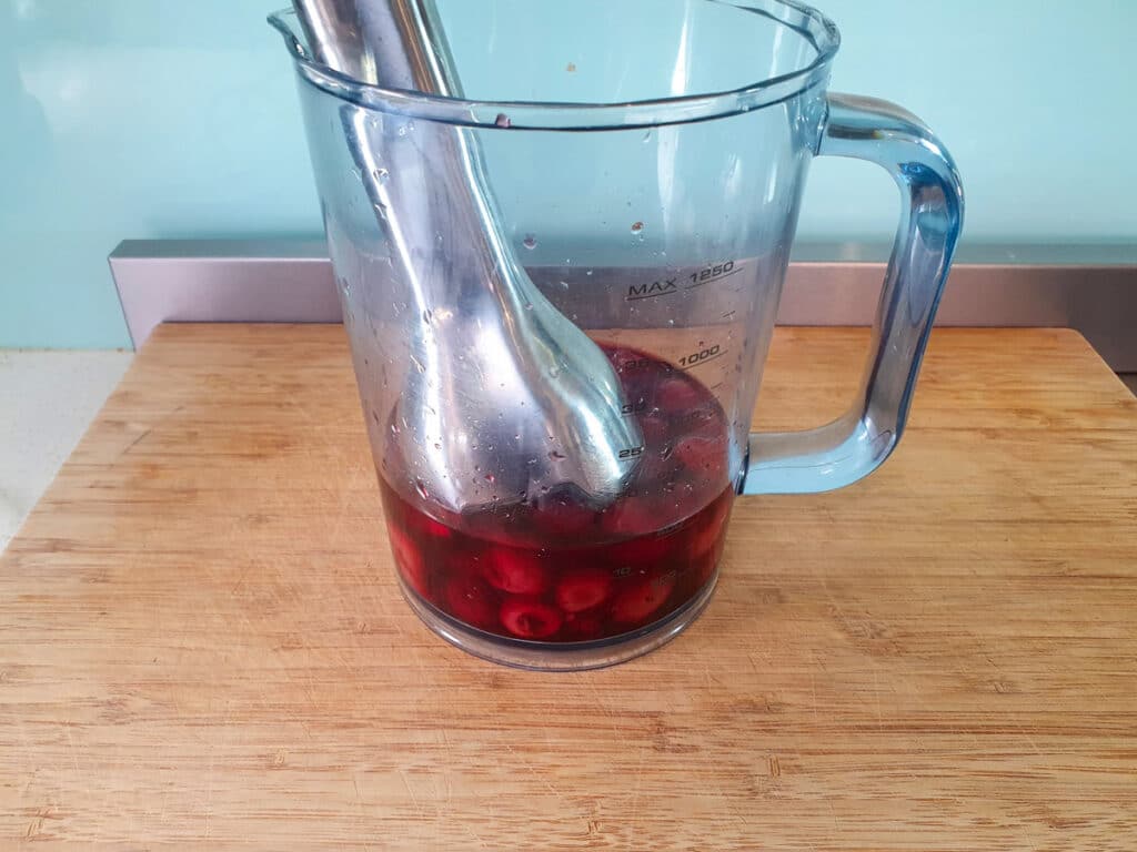 Blitzing cherries and cherry juice in a deep jug with a stick/immersion blender.