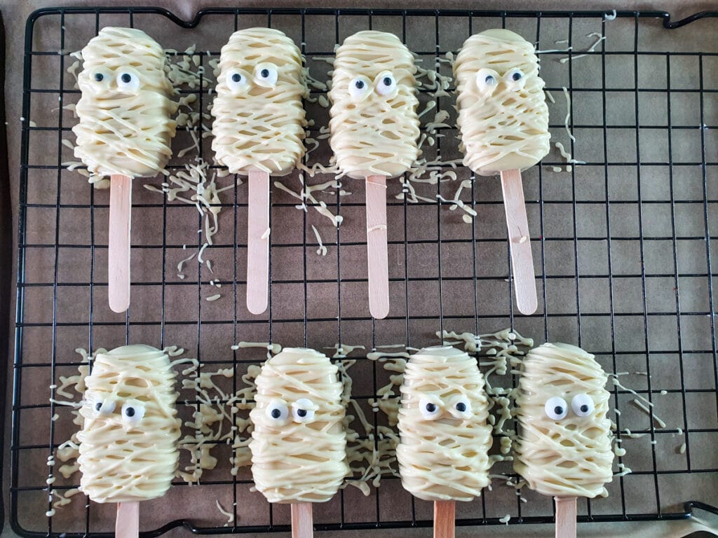 Halloween cakesicles 33 Laying more chocolate over cakesicles to form mummy bandages.